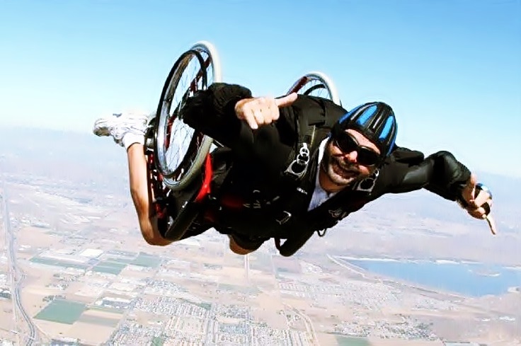 Un hombre en silla de ruedas sonríe mientras cae al vacío al practicar paracaidismo 