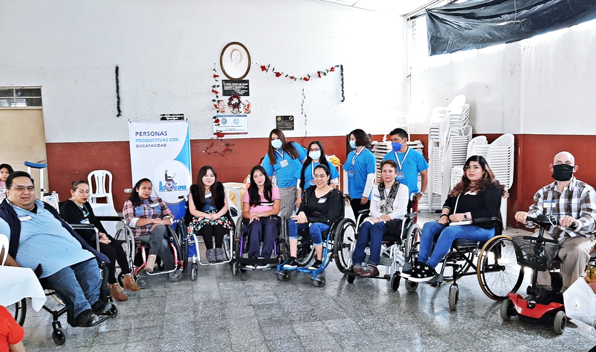 4 Asistentes institucionales de Asodispro están de pie tras 9 personas con discapacidad en sus sillas de ruedas después de un taller de capacitación.