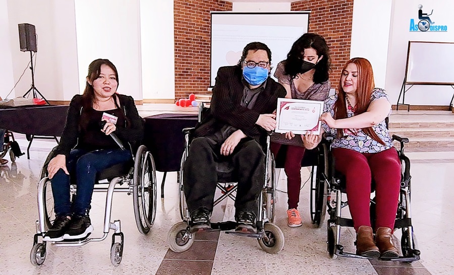 Entrega de diploma a Byron Pernilla, Jessica y Lucrecia, los tres en silla de ruedas reciben apoyo de Melani.