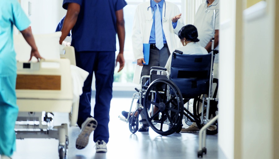 Una mujer en silla de ruedas es atendida  por un médico en un hospital 