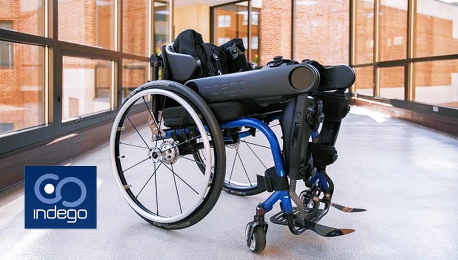 En una silla de ruedas descansa unas piernas robóticas. 