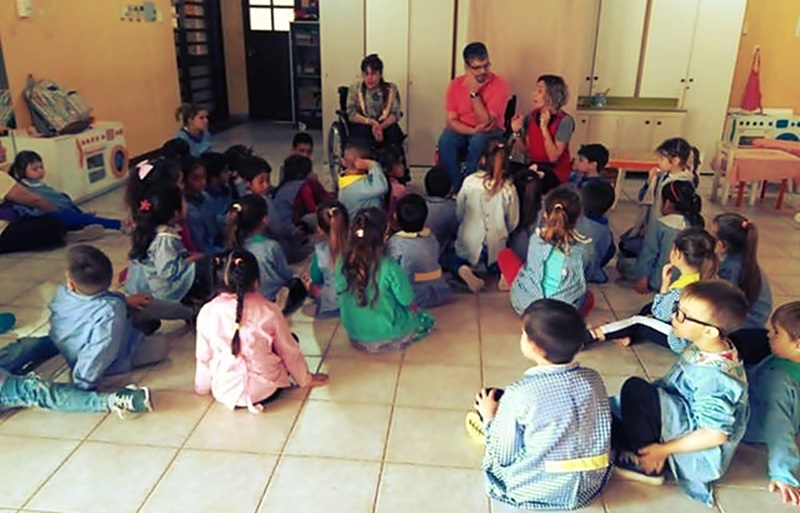 Daiana y su novio conversan con un grupo de niños que les escuchan atentamente