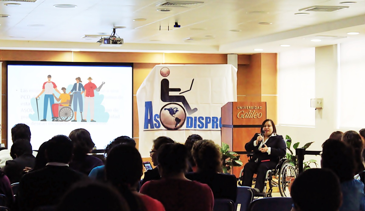 Licda. Lissette Veliz de Asodispro en su silla de ruedas, frente al público en una conferencia en Universidad Galileo 
