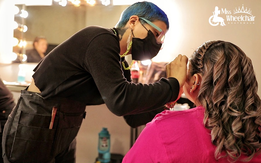 Una  estilista a quilla una una modelo de Miss Wheelchair Guatemala