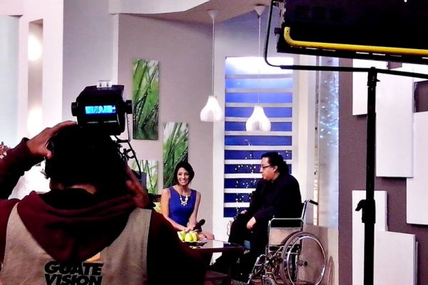 En un set de Viva La Mañana de Guatevisión, Byron Pernilla es entrevistado por María Rene.