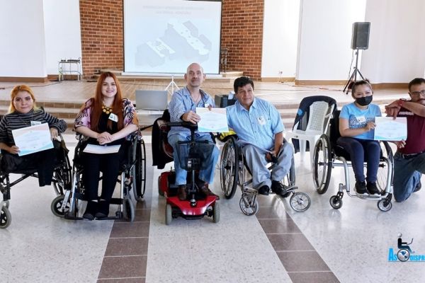 Participantes y gestores del taller, todos personas con discapacidad, posan con sus diplomas de participación.