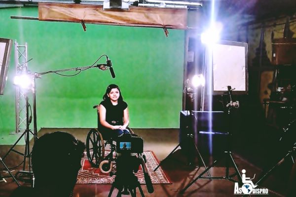 Yojana Chávez de Asodispro, en su silla de ruedas, está en un set de televisión durante la capacitación