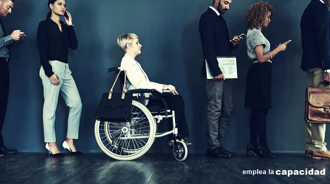 Una mujer en silla de ruedas hace cola junto a personas sin discapacidad, esto para una entrevista de trabajo